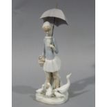 A Lladro figure of a young girl carrying an umbrella, ducks and ducklings at her feet, 28cm high,