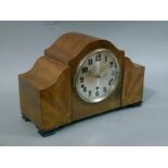 An Art Deco style walnut veneered mantel clock the silvered dial with Arabic numerals flanked by