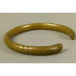 A torque bangle in bronze with a hatched and banded chased design