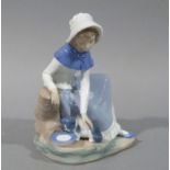 A Nao porcelain figure of a young girl seated, stroking a cat, 20cm high,