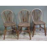 A set of three ash and elm kitchen chairs with vertical railed backs and saddled seats,