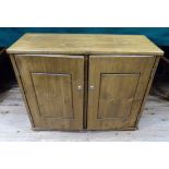 A stained pine coin cabinet fitted with multi-drawers enclosed by a pair of doors,