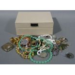 A quantity of costume jewellery contained within a cream coloured jewellery box by stackers