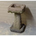 A concrete pedestal planter, the square top on tapered pillar and canted square base, 66cm high,