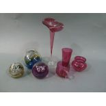 A cranberry glass jack in the pulpit vase, two paper weights, one by Caithness, the other unsigned,