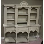 A reproduction painted breakfront dresser with flared cornice centred on a leaf filled arch,