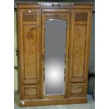 An Edwardian walnut wardrobe with single mirrored door, fitted with interior rail and hooks,