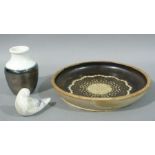 A studio pottery circular dish decorated to the centre with a stylised sunburst,