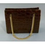 A dark brown crocodile handbag with twin gilt curb link chain straps the interior lined in a pale