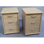 A pair of pale wood effect melamine three drawer bedside chests