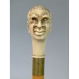A reproduction resin topped walking cane, the pommel molded as a demonic head, 89cm long