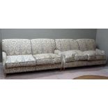A pair of two seater sofas upholstered in pale sage green, pale lilac and beige
