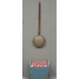 A Lloyd loom linen basket and a brass warming pan with turned handle