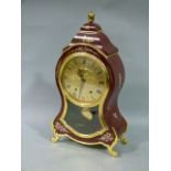 A reproduction Continental mantel clock, having a gilt metal dial with black Roman numerals,