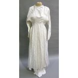 A 1950s ivory full length wedding dress, the fabric with leaf design having a square neck line and