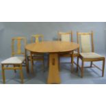 A pale elm drop leaf oval dining table and two sets of two dining chairs