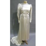 A 1930s ivory satin wedding dress having a shaped neckline, semi rouched bodice button details to