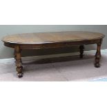 An oak oval extending dining table having a moulded rim, apron and on turned legs carved with