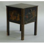 A chinoiserie black lacquered gilt and red sewing cabinet having a drop down front, the interior