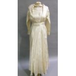 A 1940s full length ivory satin wedding dress with pleated detail to the bodice belt and long