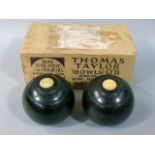 Thomas Taylor (Bowls) Ltd - A pair of ebonised lignum bowls with inset ivory roundels, stamped