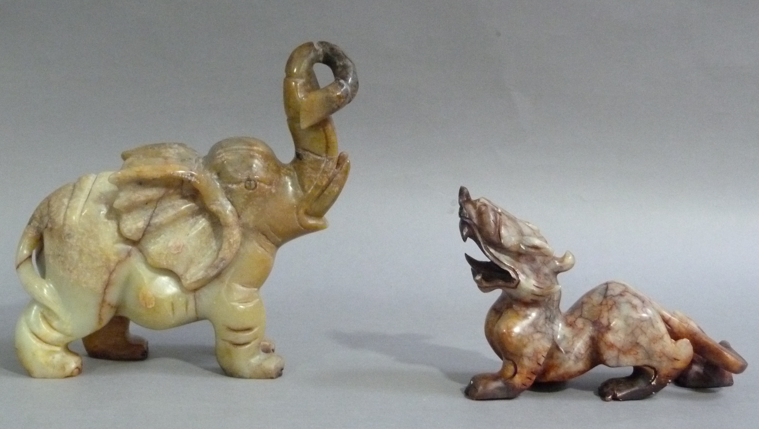 An onyx figure of an elephant its trunk raised; together with a hardstone carving of a dragon