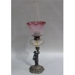 A Victorian oil lamp with cast iron figural base, clear glass reservoir, duplex burner shaded acid