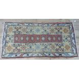 A middle eastern rug the pale yellow field with coral central rectangular panel and filled with