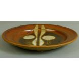 A Studio pottery charger of circular shape decorated with two circles and two shaped bars on a