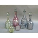 Four coloured glass decanters with faceted globular stoppers; together with a set of three