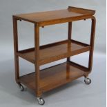 An Art Deco style walnut three tier trolley with swept upper tier, two trayed tiers beneath on