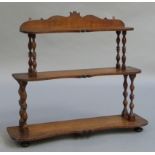 A walnut and oak three tier hanging wall shelf with turned supports