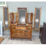 A Victorian walnut dressing chest having a rectangular bevelled mirror flanked by pierced back and