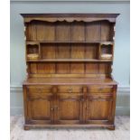 An oak dresser and rack of 18th century style having a planked back with shelves and small