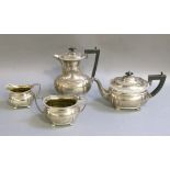 A George III style four piece boat shaped silver tea service comprising hot water jug, teapot, two