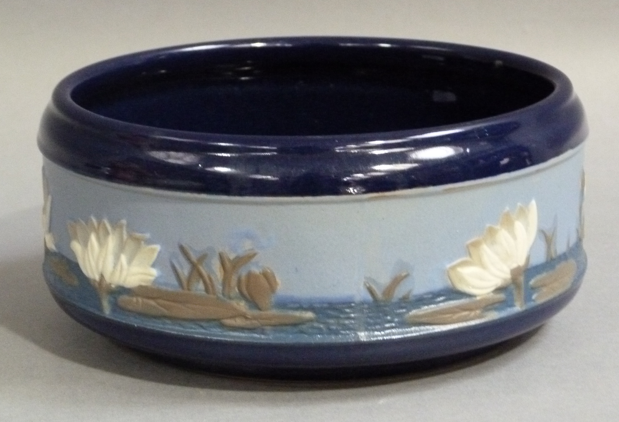 A Lovatt's Langley ware circular bowl, relief decorated to the body with a band of lily pads and