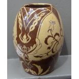 An art pottery terracotta baluster vase, decorated in creamy yellow with panels of flowers and