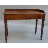 An early Victorian figured mahogany two drawer side table with three quarter gallery on turned legs,