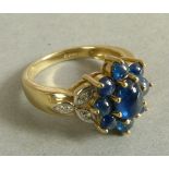 A sapphire and diamond cluster ring in 9ct gold, the circular oval cabochon sapphires claw