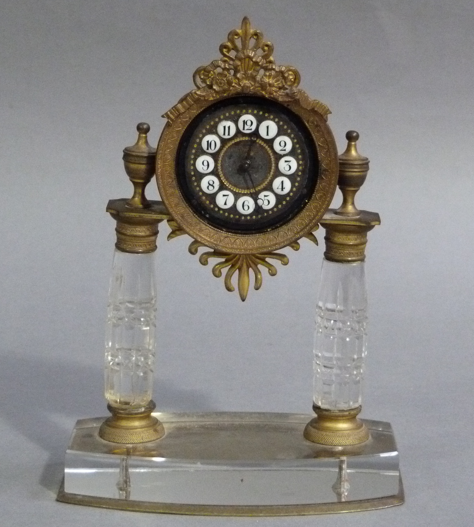 A Rock crystal and ormolu mantel clock having a circular dial with white enamel Arabic numeral