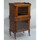 A Victorian mahogany cabinet with three quarter shaped gallery above two glazed doors and central