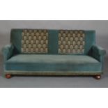 A 1920s sofa having a rectangular back, rolled arms, on large bun feet, 206cm wide