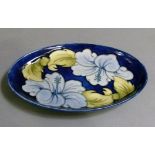 A Moorcroft Hibiscus pattern oval dish, slip trail decorated, 23cm wide, painted mark in green