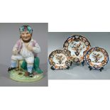 A Victorian staffordshire flat back figure of a seated gnome with grapes and leaves in his hair,