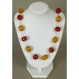 An early to mid 20th century amber necklace of rounded cylindrical beads in alternate yellow and red