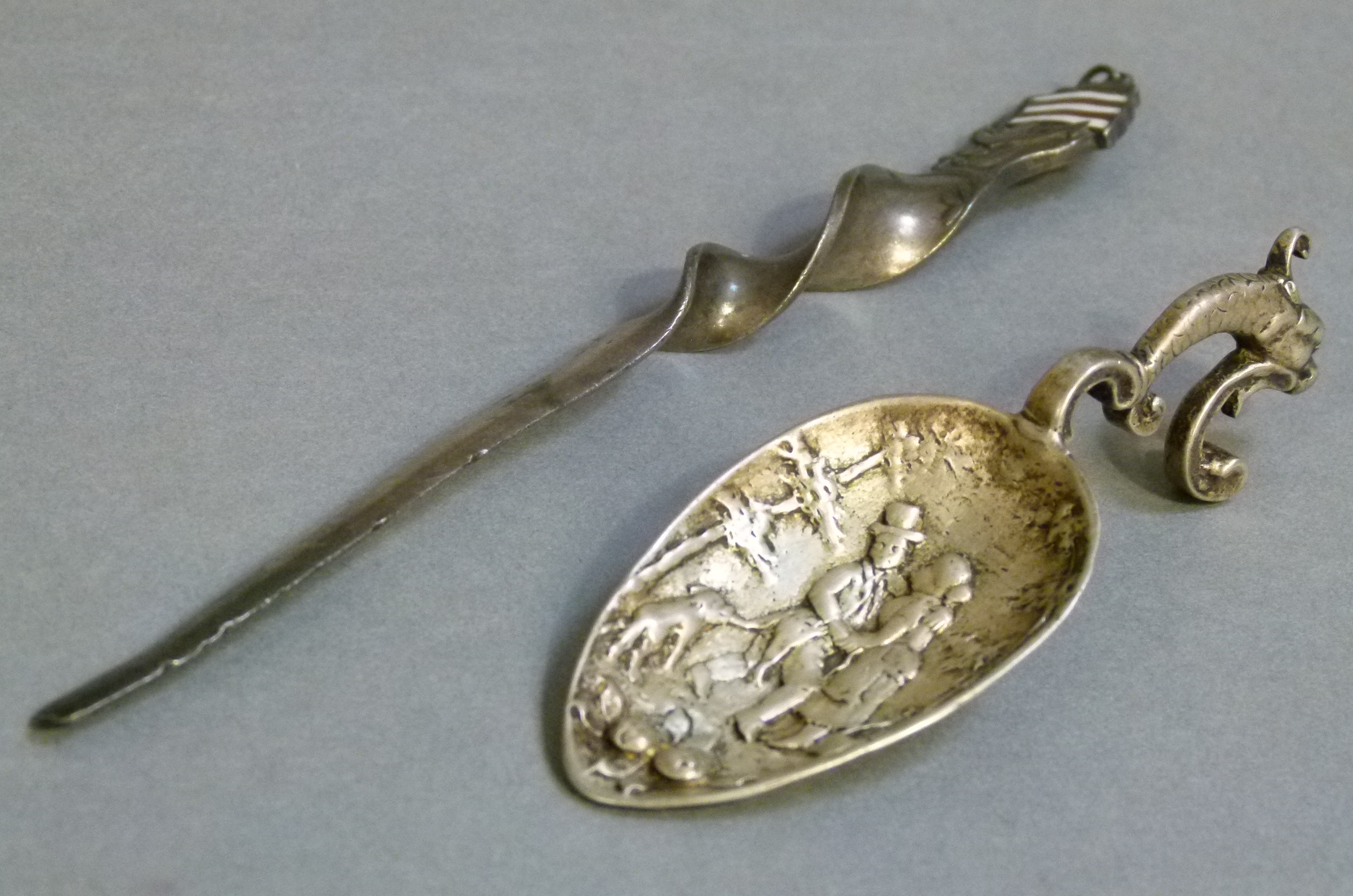 A continental caddy spoon cast with pair of lovers and dog, stylized cast dolphin handle, 9.5cm long