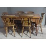 A stained pine kitchen table in Victorian style, rounded rectangular top above bowl turned legs,