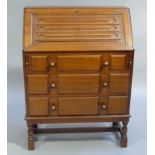 A mahogany finish linen fold bureau, having a fall front over three drawers