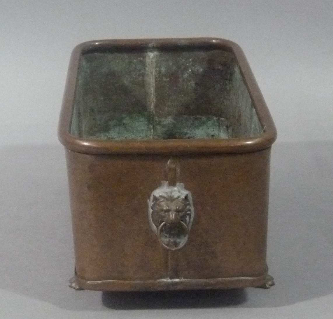 A copper planter with lion mask and ring handles on four brass lion paw feet, 29cm wide - Image 2 of 2