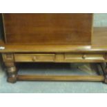 A reproduction coffee table, the rectangular top above two drawers, squat legs joined by stretchers,